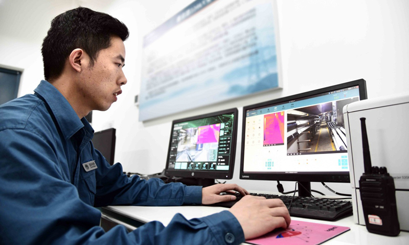 5月29日，国网青岛供电公司工作人员通过电脑遥控智能巡检机器人对地下电缆进行数据采集。（新华社记者 郭绪雷 摄）