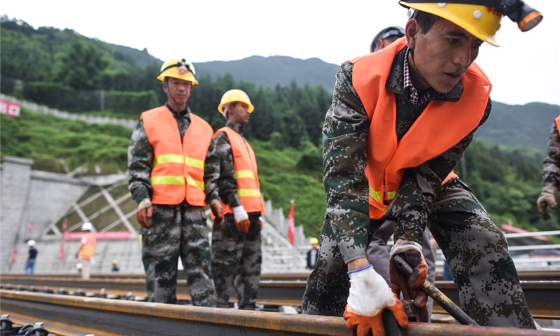 5月30日，中铁四局的建设者在四川省宜宾市兴文县境内进行铺轨作业。（新华社记者 薛玉斌 摄）
