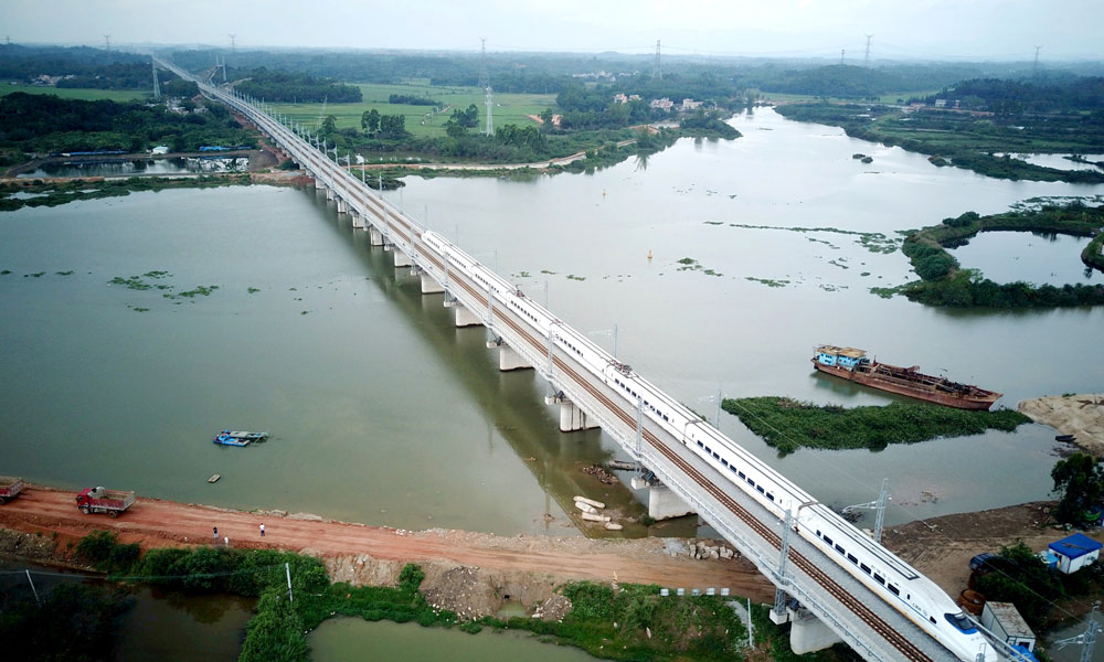 7月1日7时20分，随着首列高铁D7452从湛江西站快速驶出，连接珠三角核心城市和粤西地区的首条高速铁路——江（门）湛（江）高铁正式开通，粤西地区从此跨入高铁时代。图为动车从中铁二十三局承建的丰头河大桥通过。（马鹏飞 摄）