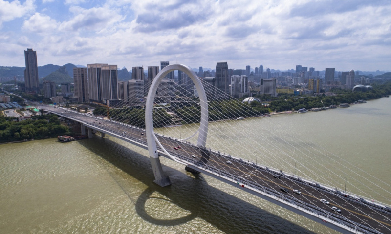 白沙大桥2015年5月开始施工，全长1920米，宽38米，主塔最高点达106米，为空间异形结构，是目前世界上最高、跨度最大的“反对称结构斜拉桥”。图为9月28日，车辆在广西柳州市白沙大桥上行驶。新华社发（李斌 摄）